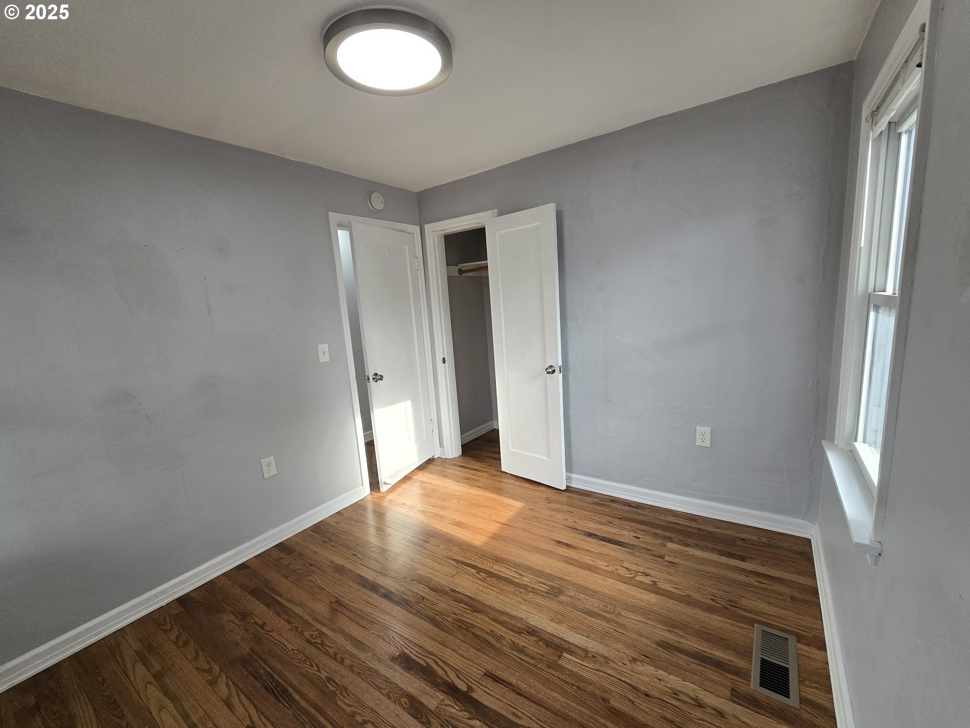 210 Southwest 3rd Street Hermiston, OR 97838 - Photo 23 of 24 an empty room with wooden floor and windows