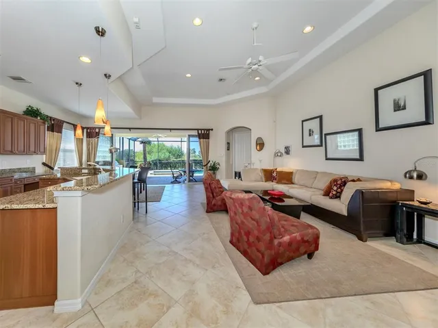 a living room with furniture and a view of kitchen