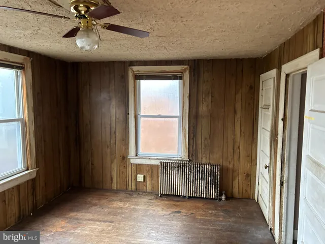 an empty room with windows and cabinet