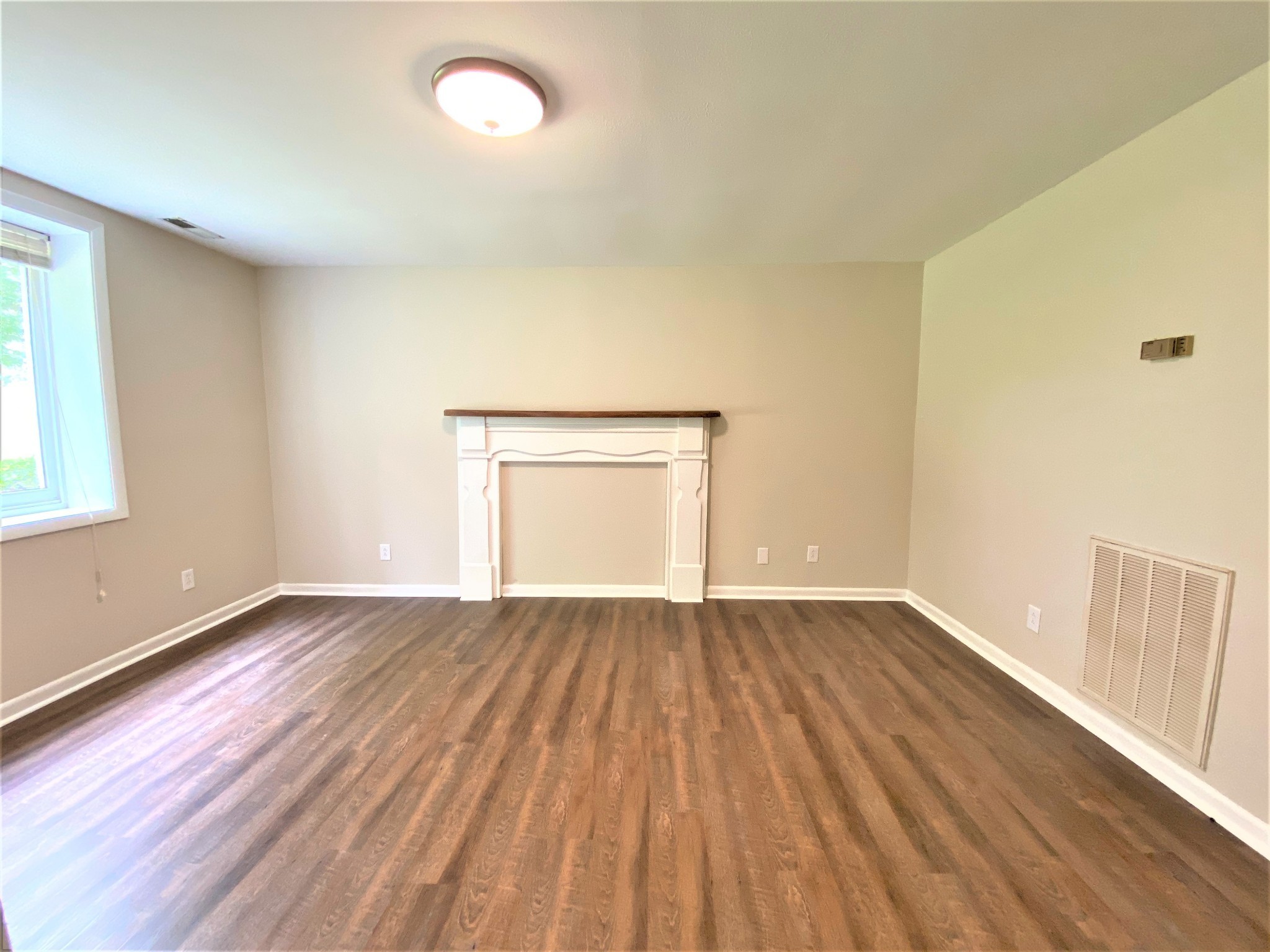 1035 West Point Road Lawrenceburg, TN 38464 - Photo 13 of 42 an empty room with wooden floor and windows