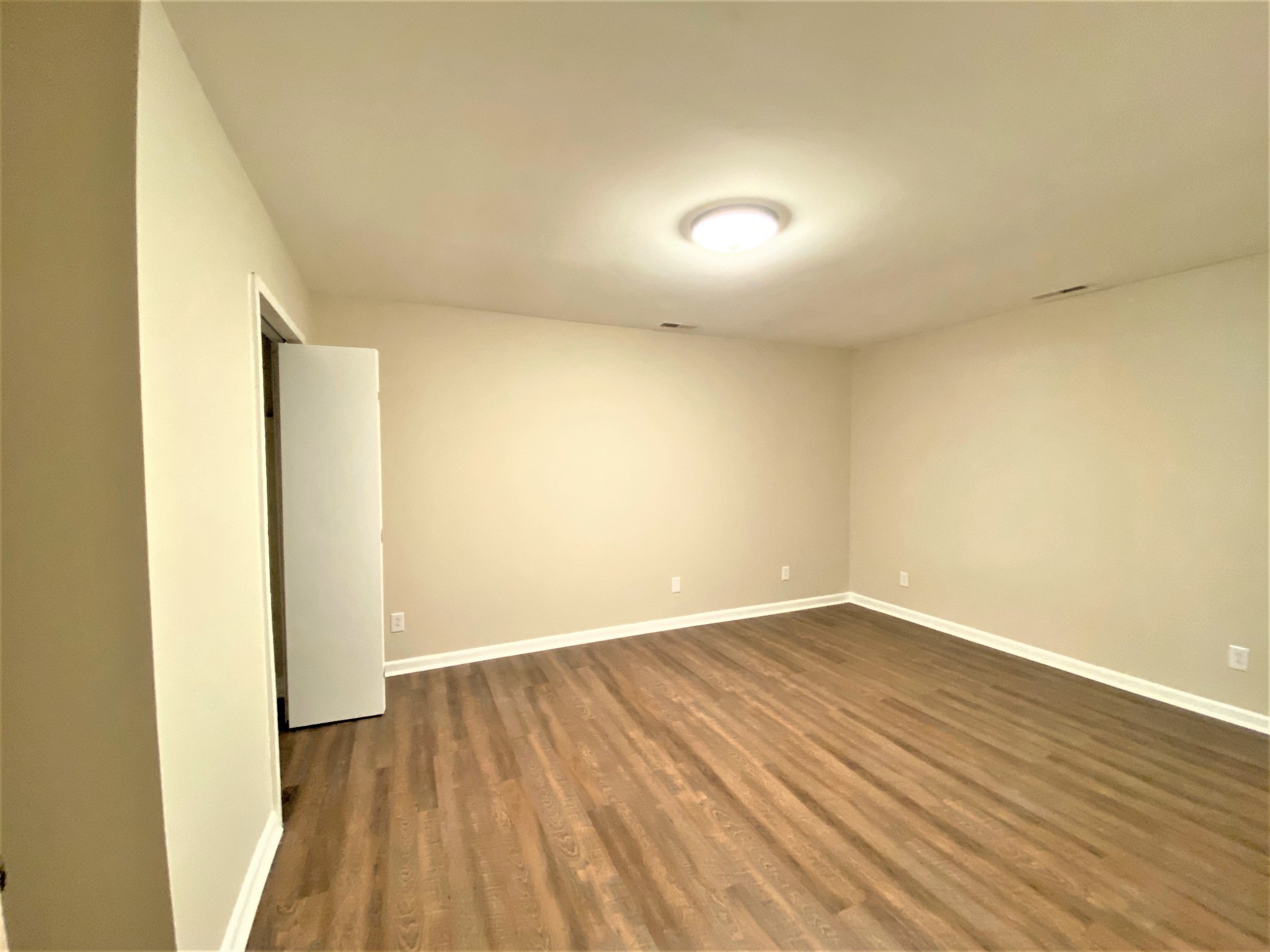 1035 West Point Road Lawrenceburg, TN 38464 - Photo 18 of 42 an empty room with wooden floor and windows