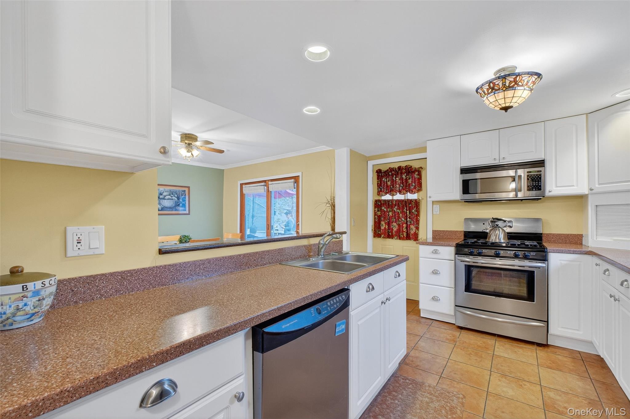 333 Canoe Hill Road Saugerties, NY 12477 - Photo 15 of 34 Kitchen with stainless steel appliances, white cabinetry, light tile patterned floors, recessed lighting, and ornamental molding