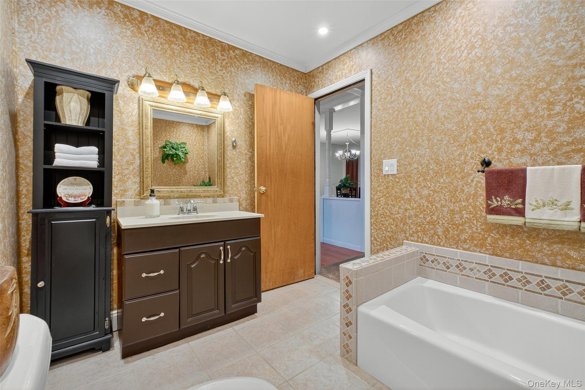 333 Canoe Hill Road Saugerties, NY 12477 - Photo 20 of 34 Full bathroom with a garden tub, vanity, crown molding, light tile patterned floors, and wallpapered walls