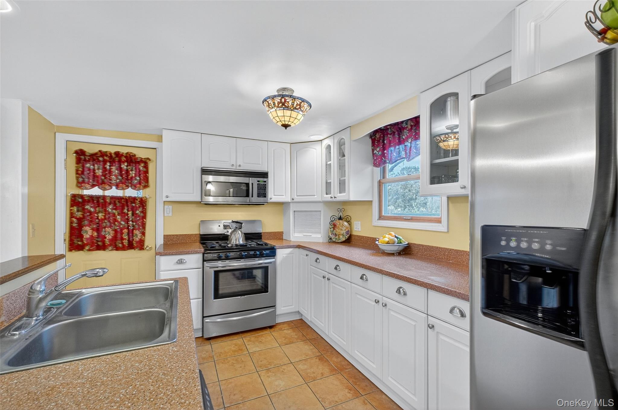 333 Canoe Hill Road Saugerties, NY 12477 - Photo 2 of 34 Kitchen with stainless steel appliances, white cabinets, glass insert cabinets, light tile patterned floors, and light countertops