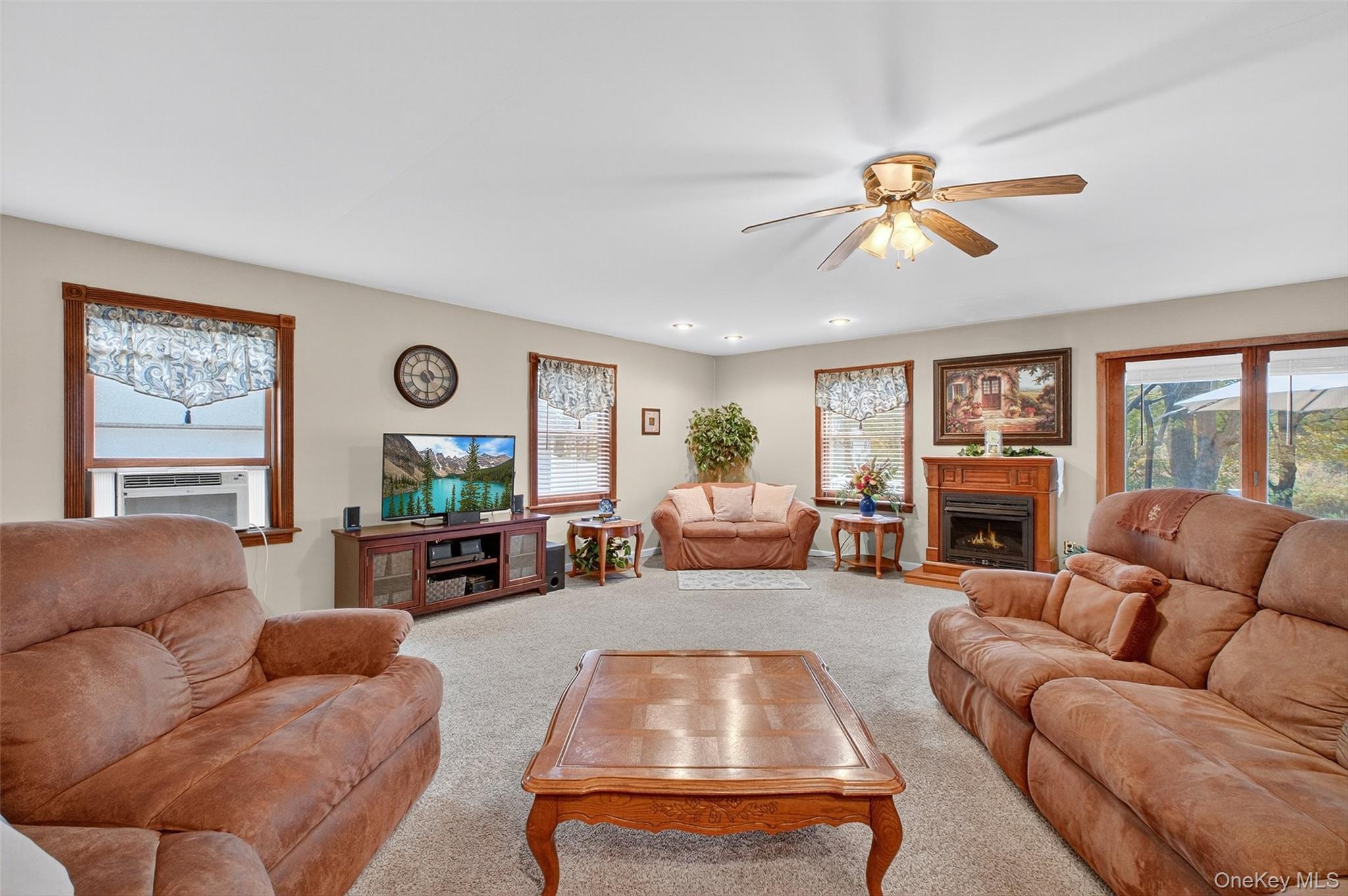 333 Canoe Hill Road Saugerties, NY 12477 - Photo 4 of 34 Living area featuring a lit fireplace, carpet, a ceiling fan, and cooling unit