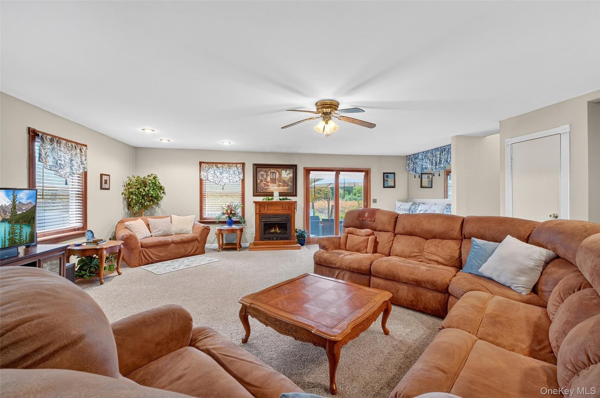 333 Canoe Hill Road Saugerties, NY 12477 - Photo 8 of 34 Living area featuring carpet flooring, a ceiling fan, and a lit fireplace