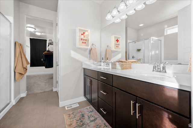 3359 Eurasian Crane Road Clinton, UT 84015 - Photo 21 of 71 Bathroom featuring a shower stall, double vanity, and a spacious closet