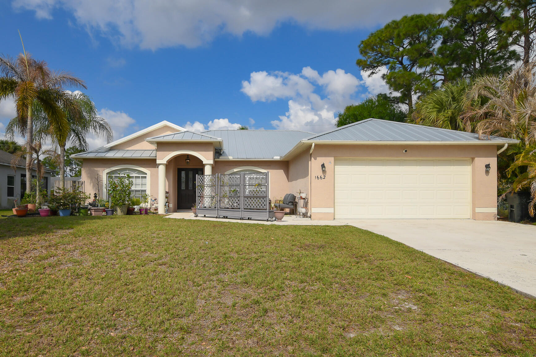 1662 Southwest Rutland Street Port St. Lucie, FL 34987 - Photo 1 of 40 a front view of a house with garden