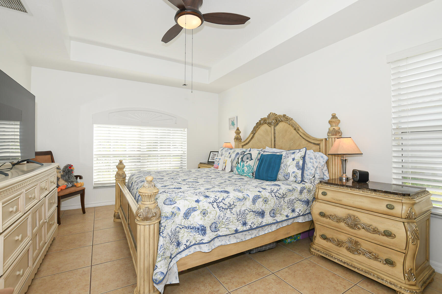 1662 Southwest Rutland Street Port St. Lucie, FL 34987 - Photo 16 of 40 a bedroom with a bed and a chandelier