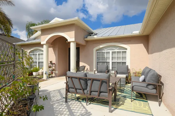 a front view of a house with outdoor seating and plants