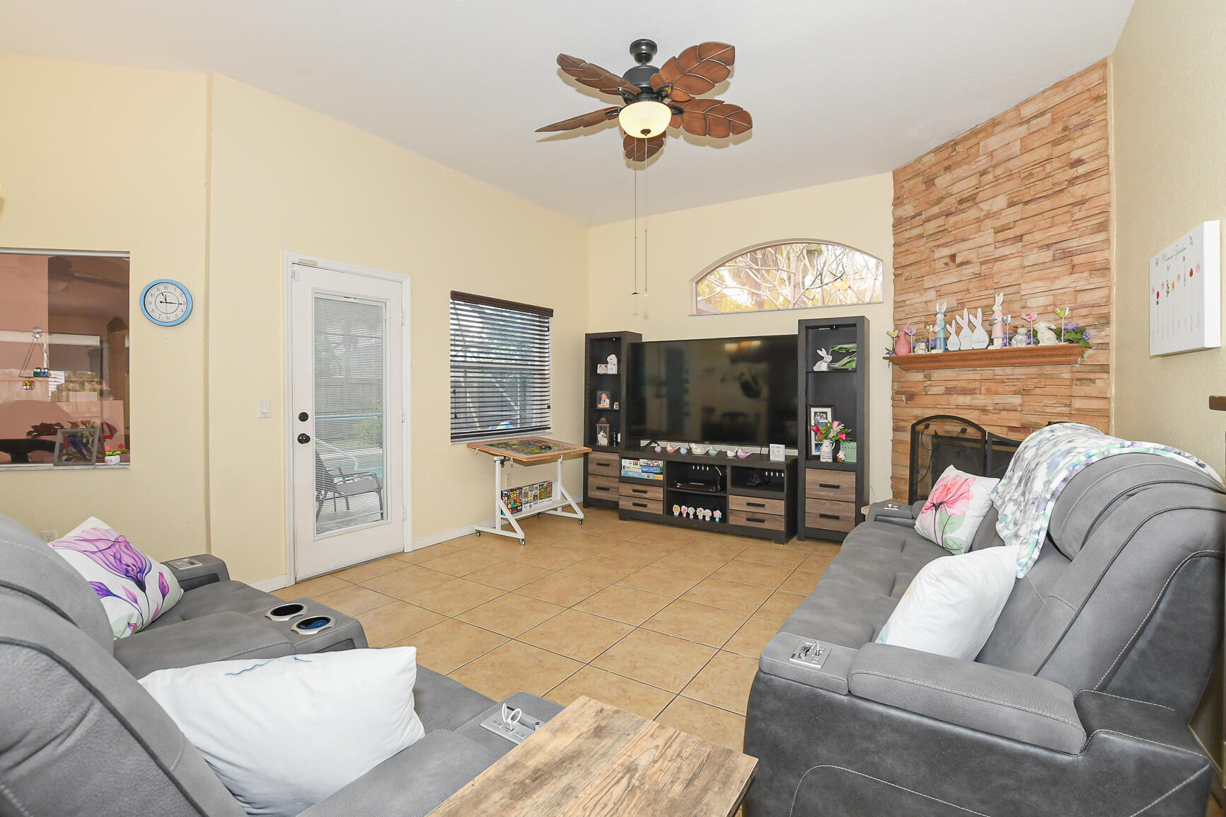 1662 Southwest Rutland Street Port St. Lucie, FL 34987 - Photo 27 of 40 a living room with furniture a fireplace and a flat screen tv