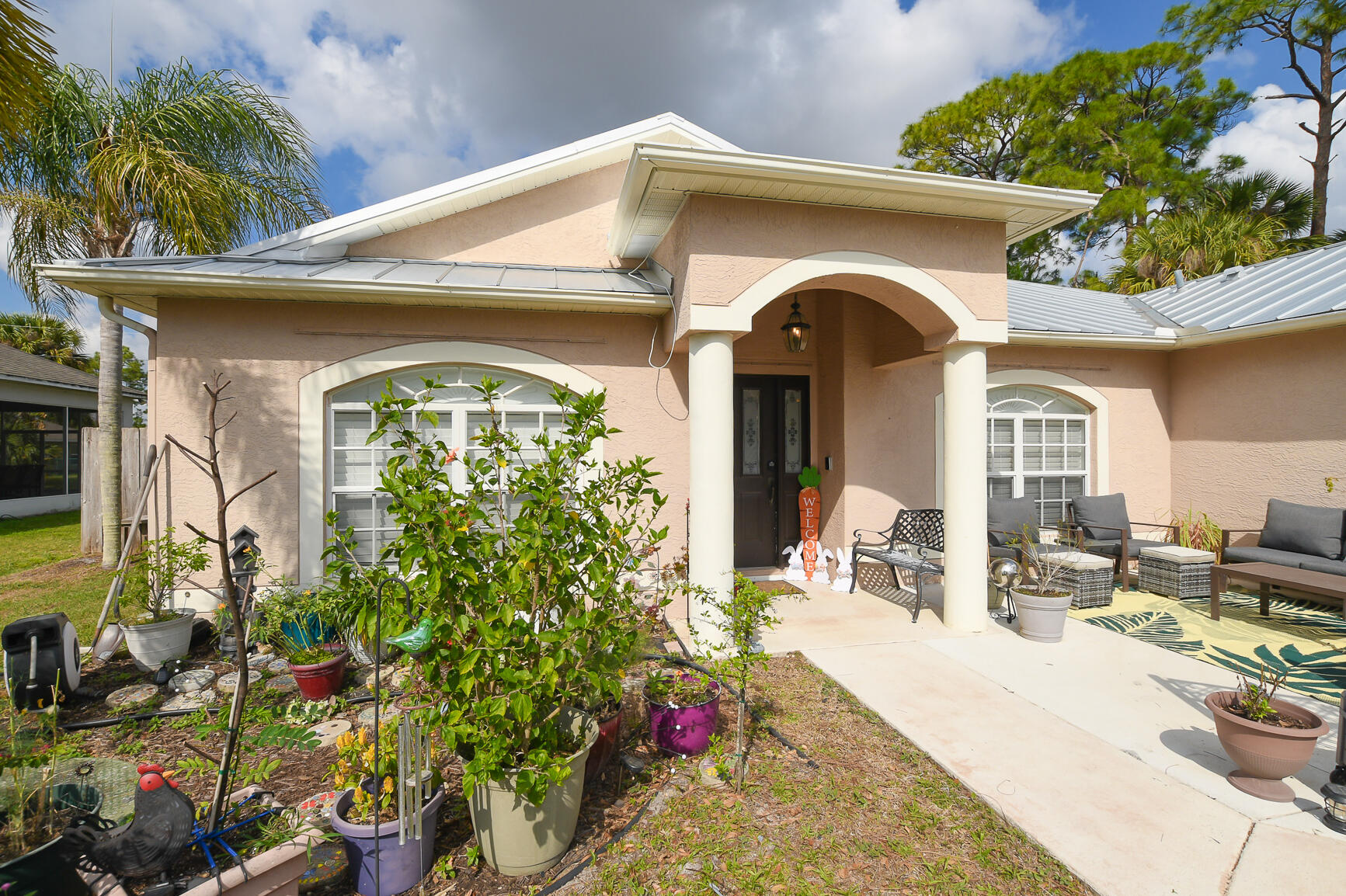 1662 Southwest Rutland Street Port St. Lucie, FL 34987 - Photo 3 of 40 a front view of a house with outdoor seating and plants