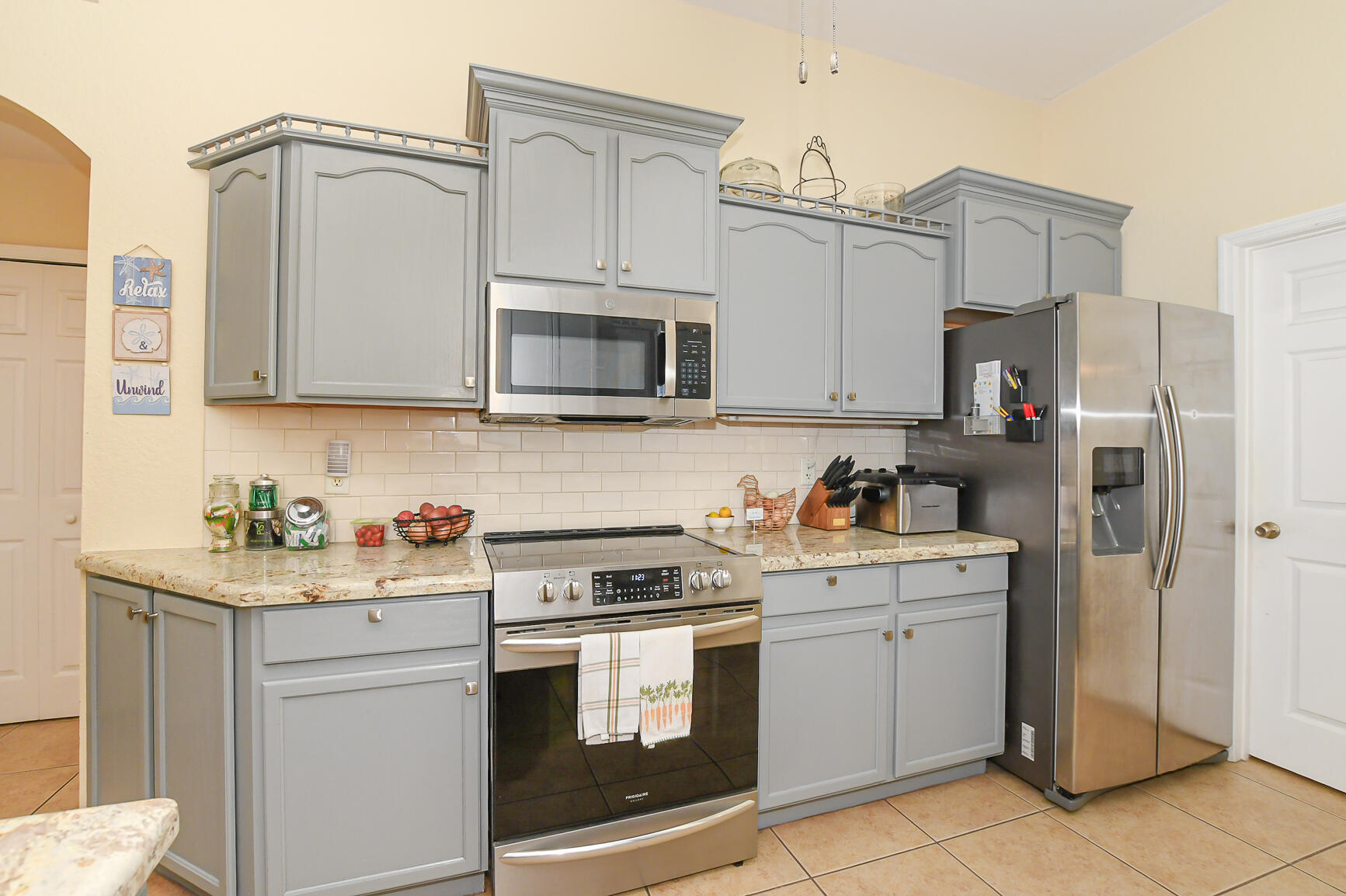 1662 Southwest Rutland Street Port St. Lucie, FL 34987 - Photo 32 of 40 a kitchen with stainless steel appliances granite countertop a refrigerator stove and sink
