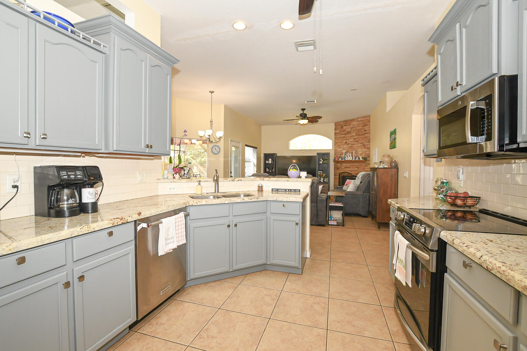 1662 Southwest Rutland Street Port St. Lucie, FL 34987 - Photo 33 of 40 a kitchen with stainless steel appliances granite countertop a stove and cabinets