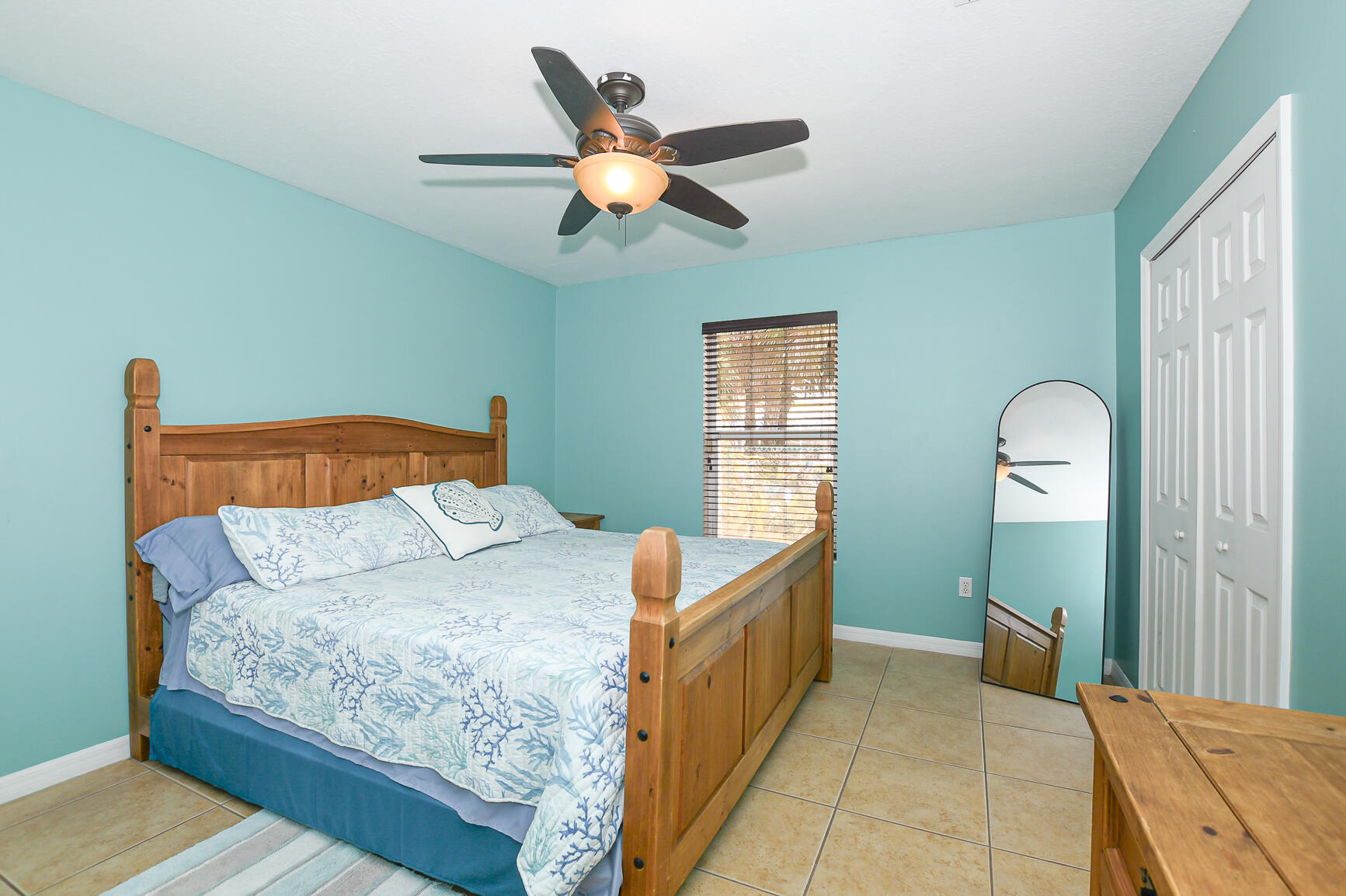 1662 Southwest Rutland Street Port St. Lucie, FL 34987 - Photo 34 of 40 a bedroom with a bed and a chandelier
