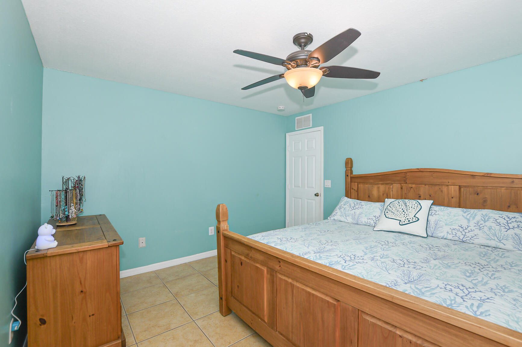 1662 Southwest Rutland Street Port St. Lucie, FL 34987 - Photo 35 of 40 a bedroom with a bed and a chandelier