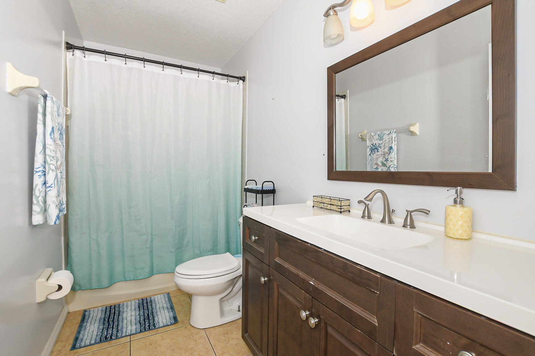 1662 Southwest Rutland Street Port St. Lucie, FL 34987 - Photo 36 of 40 a bathroom with a toilet a sink and a mirror