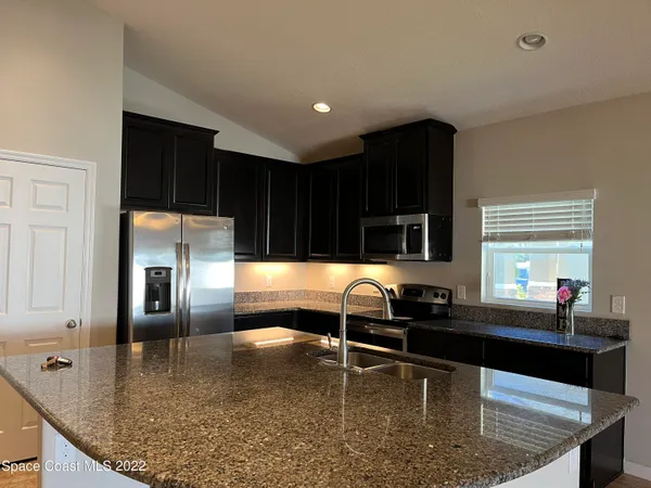 a kitchen with stainless steel appliances granite countertop a sink stove and cabinets