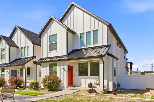 153 East Rochefort Court Sandy, UT 84070 - Photo 1 of 43 Modern farmhouse exterior with vertical white siding, black-frame windows, and a prominent red entry door
