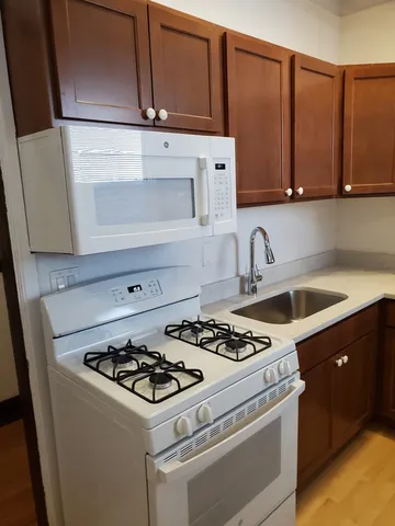 a white stove top oven sitting inside of a kitchen