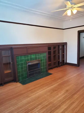 a view of a room with a wooden floor and a fireplace