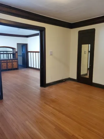 a view of empty room with stairs and wooden floor