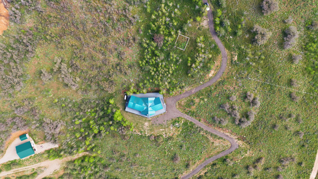 6 Beaver Springs Rancheros Oakley, UT 84055 - Photo 62 of 68 Aerial perspective of a verdant landscape featuring a central structure with a teal multi-faceted roof