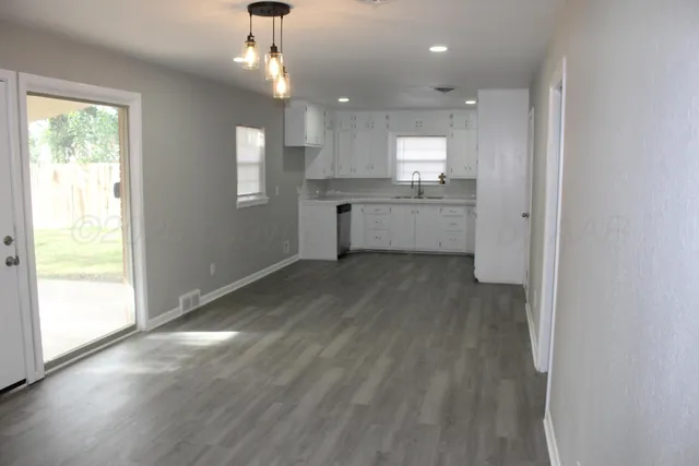 a view of a kitchen with wooden floor and a window