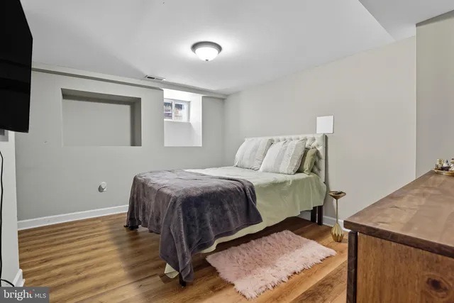 a bedroom with a bed and wooden floor
