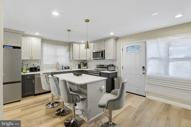 a kitchen with a sink a refrigerator a counter top space and cabinets
