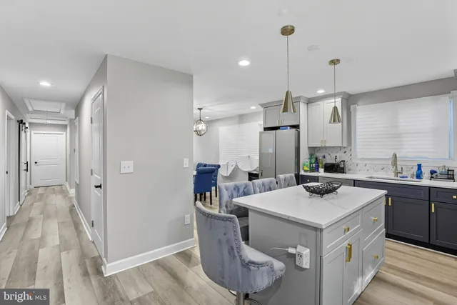 a kitchen that has a lot of cabinets in it and wooden floors
