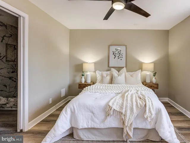 a bedroom with a bed and painting on the wall