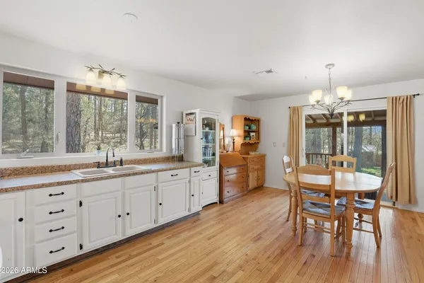 a kitchen with granite countertop a dining table chairs sink and wooden floor