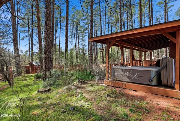 a balcony with wooden floor outdoor seating and yard in the back