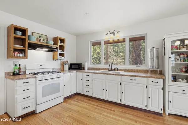 a kitchen with cabinets a sink and dishwasher with wooden floor