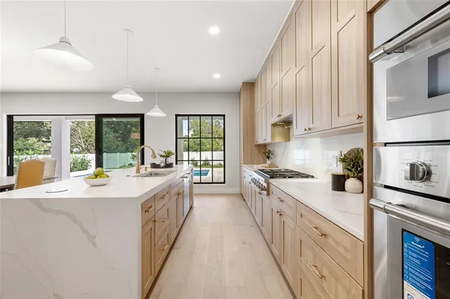 a kitchen with kitchen island granite countertop a stove and a view of living room