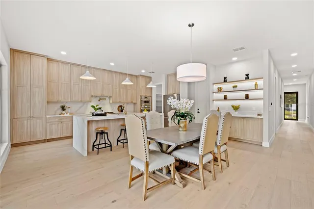 a living room with furniture kitchen view and a potted plant