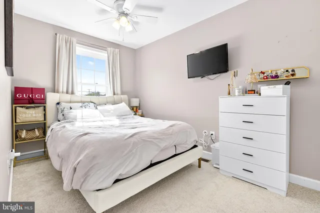 a bedroom with a bed and a flat tv screen on dresser