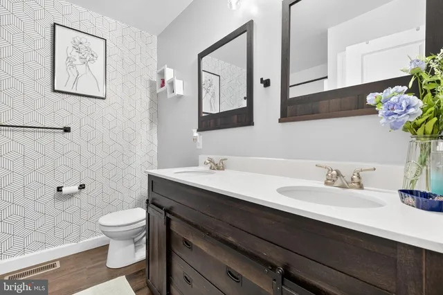 a bathroom with a granite countertop sink a toilet and a mirror