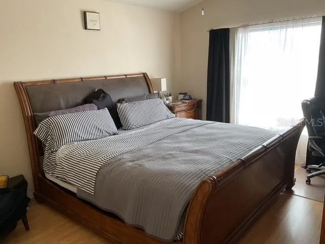 a bedroom with a bed and wooden floor