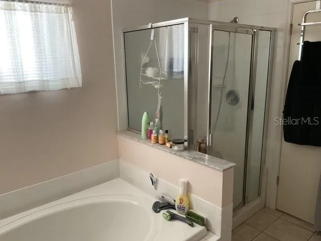 a bathroom with a sink a mirror a window and shower