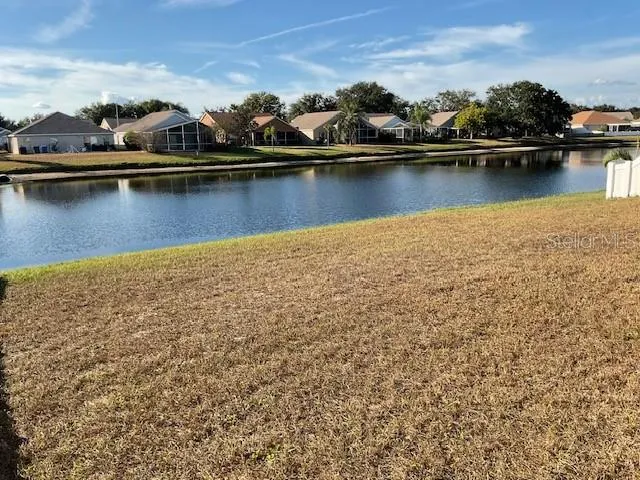 an aerial view of residential houses with outdoor space and lake view