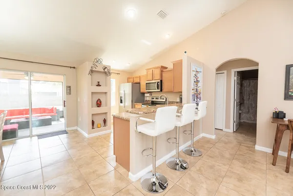 a large white kitchen with a large window and refrigerator