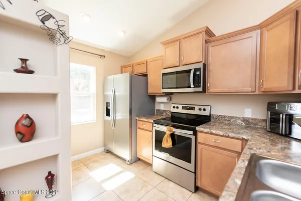 a kitchen with stainless steel appliances granite countertop a stove a refrigerator and a microwave