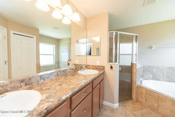 a bathroom with a granite countertop sink and a bathtub
