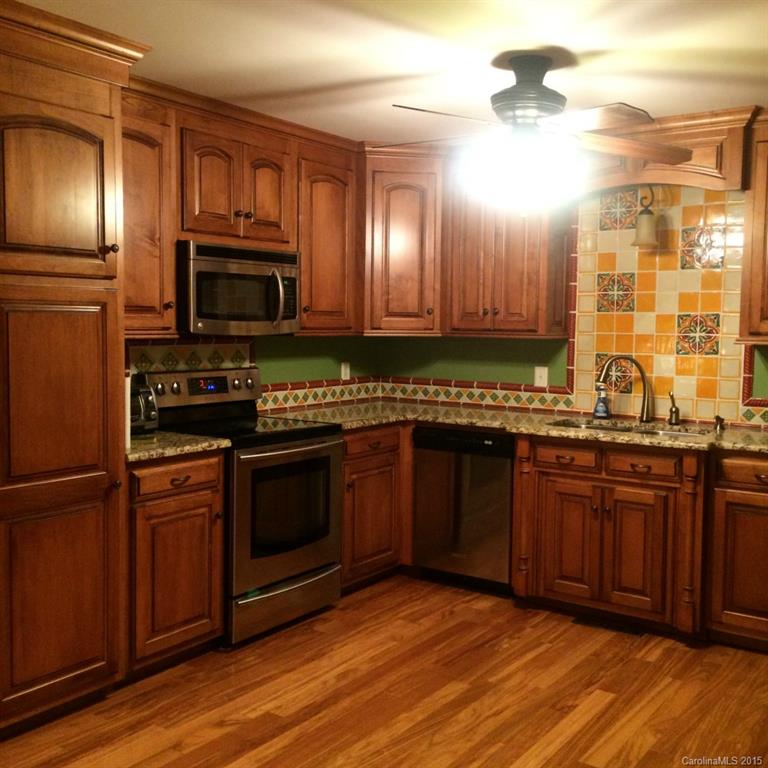 4521 Stack Road Monroe, NC 28112 - Photo 11 of 24 a kitchen with stainless steel appliances granite countertop a stove a microwave and a refrigerator