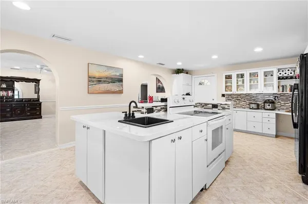 a kitchen with white cabinets appliances and a sink