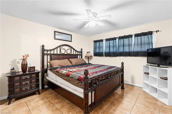 a bedroom with a bed and a flat tv screen on the dresser