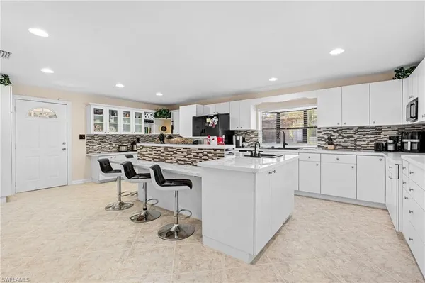 a kitchen with a sink and chairs