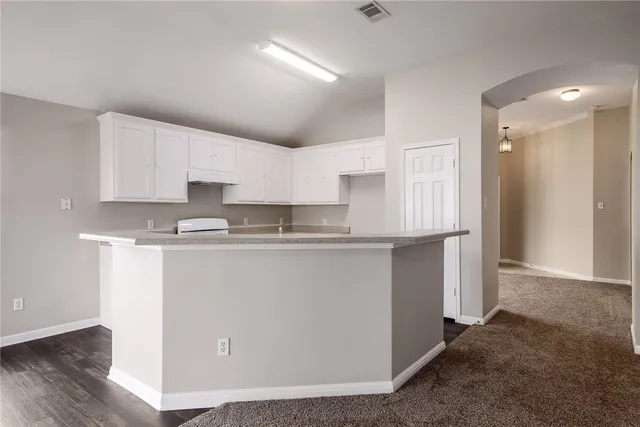 a kitchen with kitchen island granite countertop a sink cabinets and stainless steel appliances